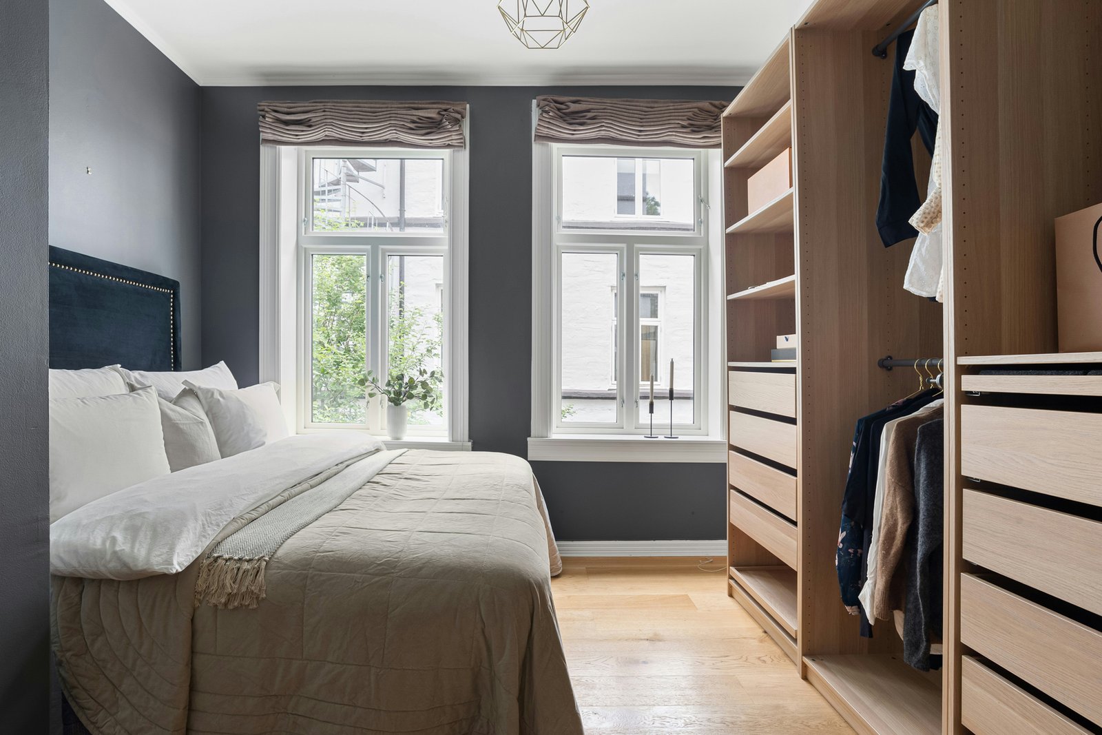 Innenraum eines Holzkleiderschranks mit Regalböden und Kleidung