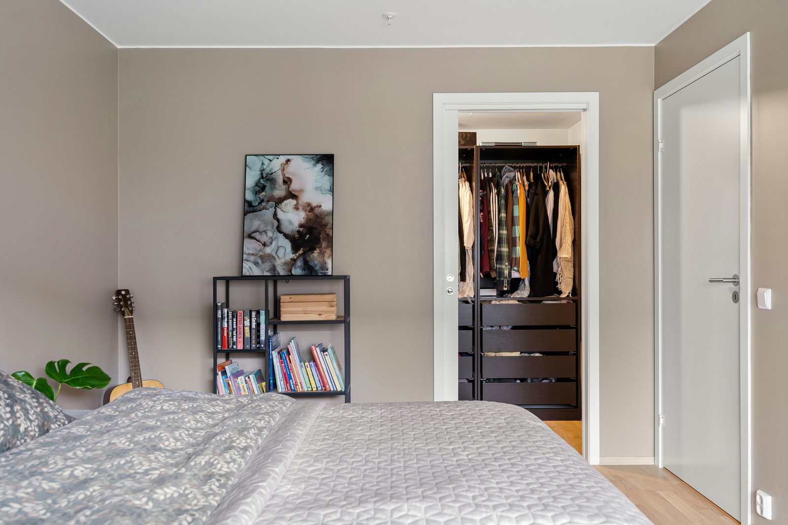 Offener Kleiderschrank mit Kleidung auf Bügeln und Regalböden